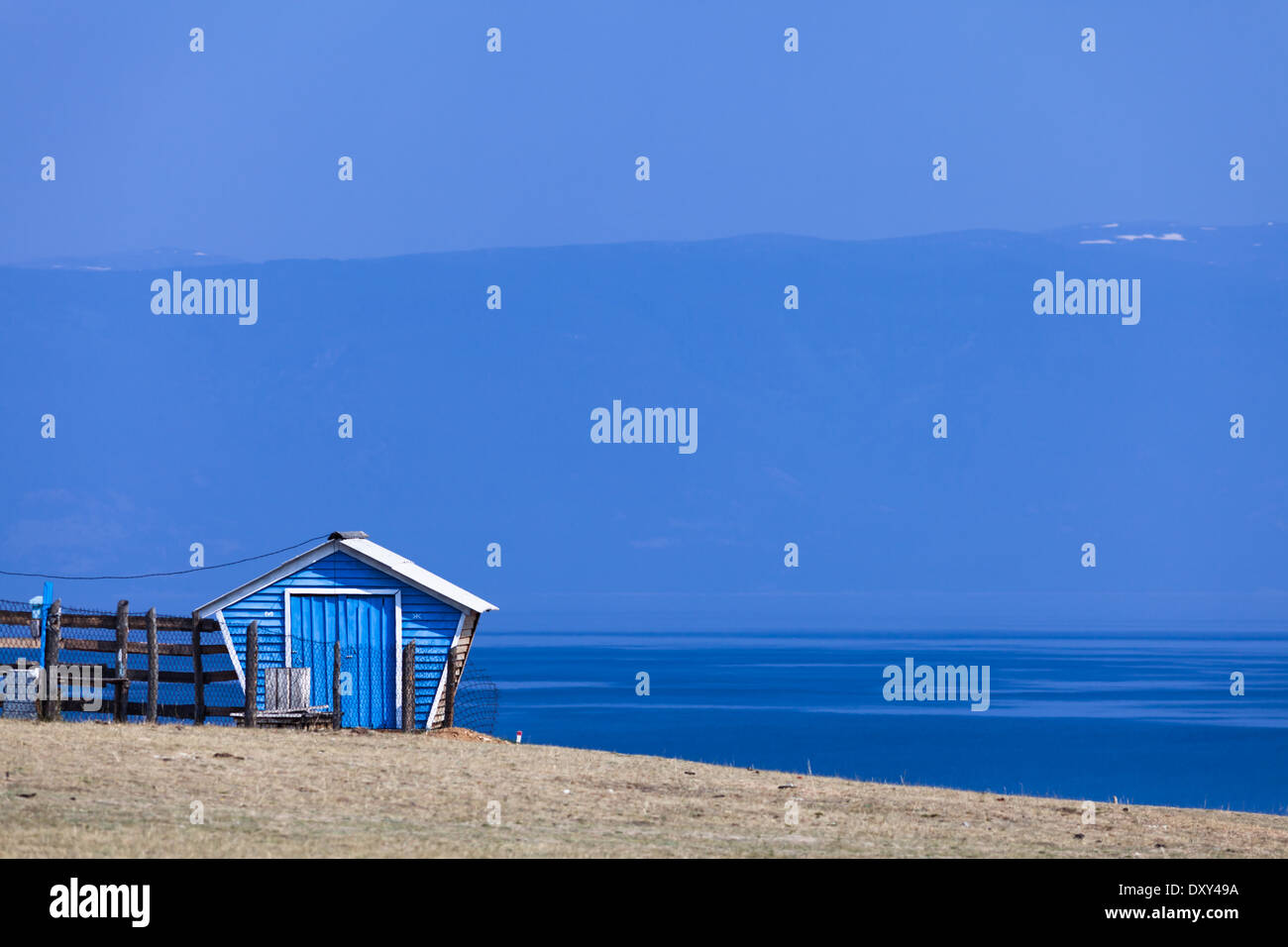 Blue cottage on Olkhon Island and a view on part of Lake Baikal (Siberia, Russia) called Small Sea Strait and on the western shore of Baikal Stock Photo