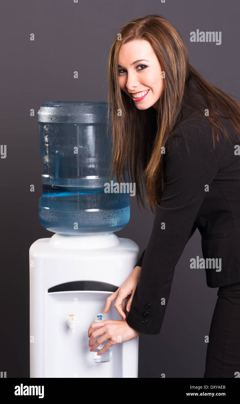 Young adult female at water cooler in workplace Stock Photo Alamy