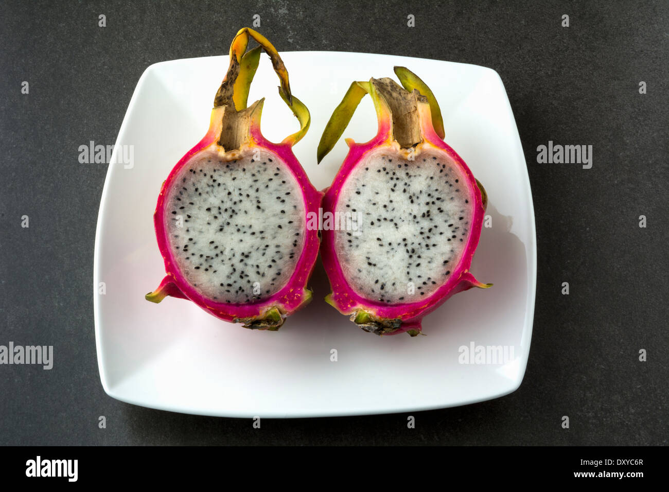 Dragon fruit cut in half on white plate Stock Photo