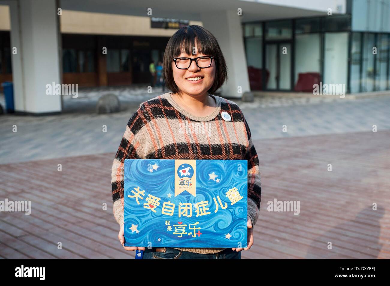 (140402) -- BEIJING, April 2, 2014 (Xinhua) -- Li Xiang, a volunteer for autistic children, holds a placard reading 'care for autistic children' in Beijing, capital of China, March 15, 2014. The World Autism Awareness Day falls on April 2, drawing attention to the pervasive developmental disorder that affects tens of millions of children around the globe.    (Xinhua/Zhang Keren) (wf) Stock Photo