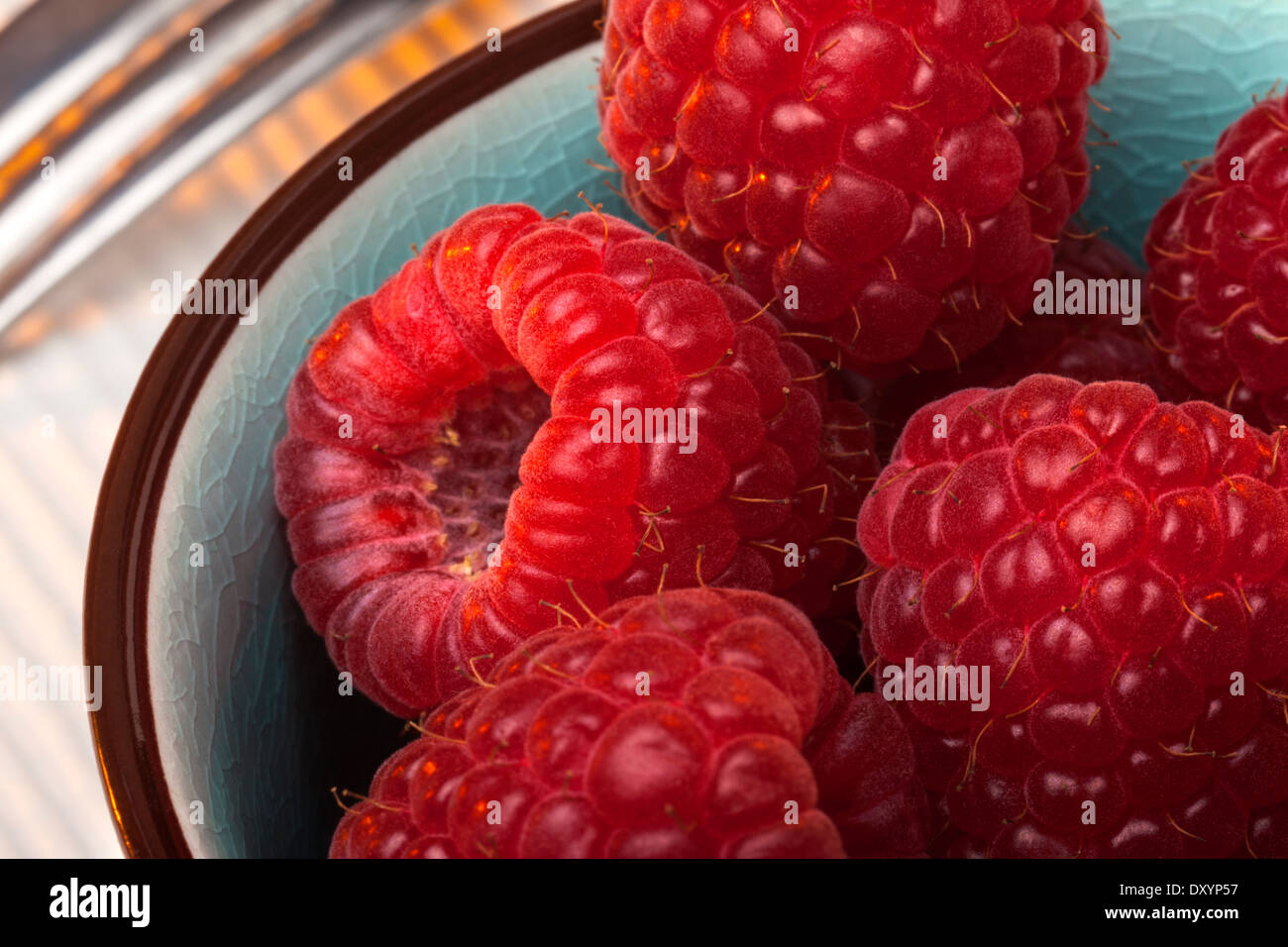 Raspberries are an edible soft fruit related to the blackberry, consisting of a cluster of reddish-pink drupelets. Stock Photo