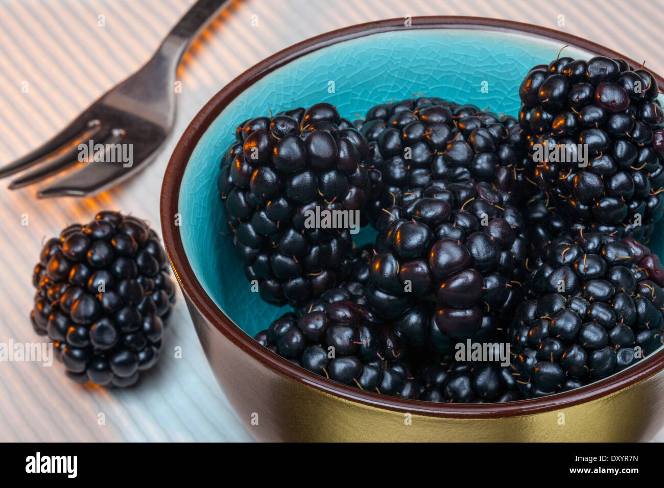 Blackberries are an edible soft fruit consisting of a cluster of soft purple-black drupelets. Stock Photo