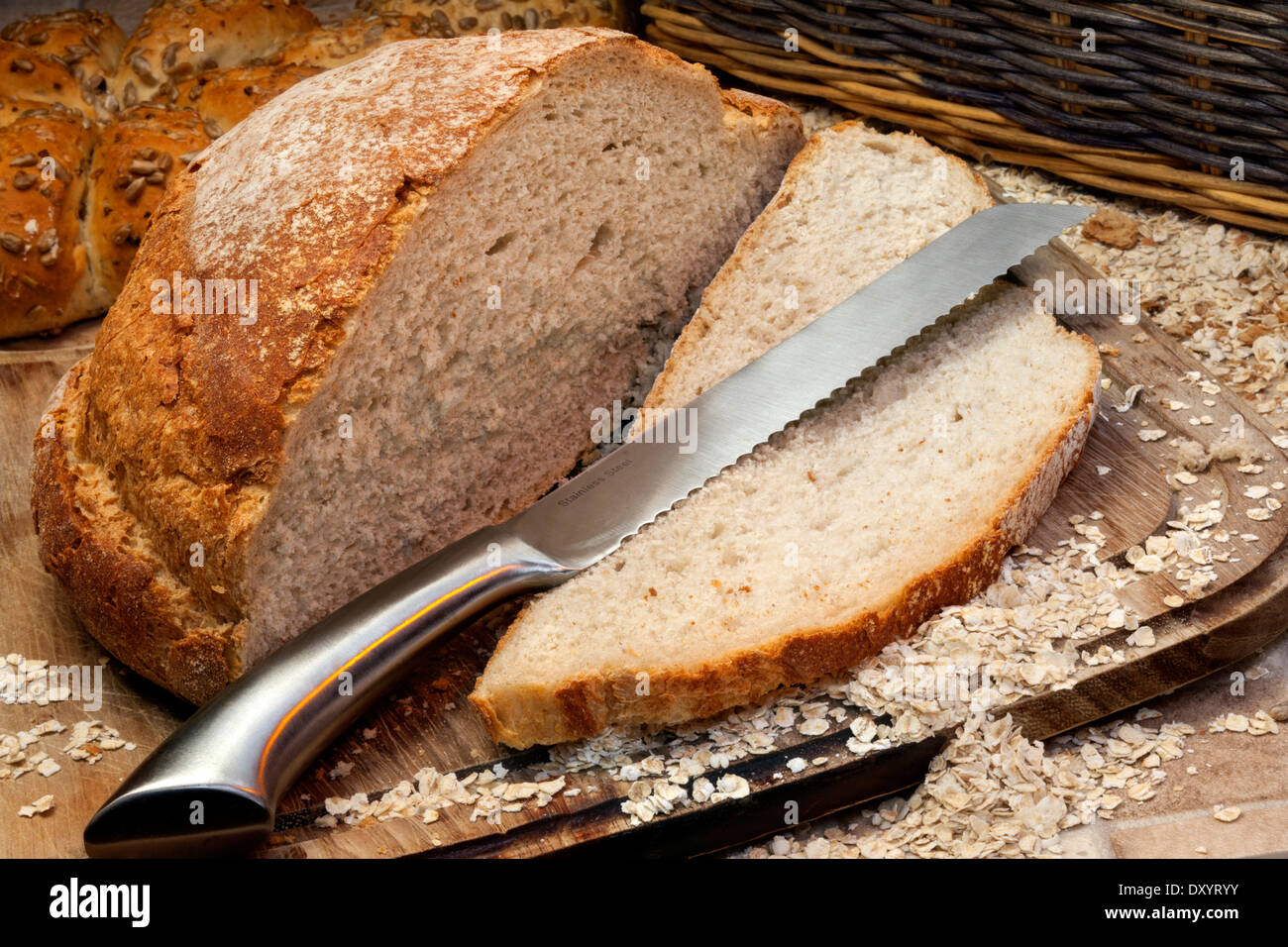 A freshly baked loaf of bread on a breadboard in farmhouse kitchen Stock Photo