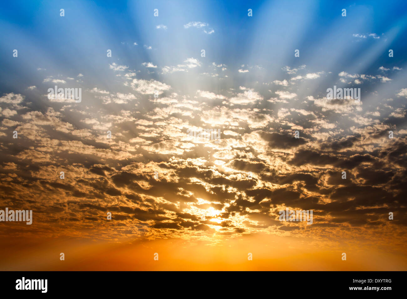 Dramatic Sunbeam through cloud blue and orange twilight sky background Stock Photo