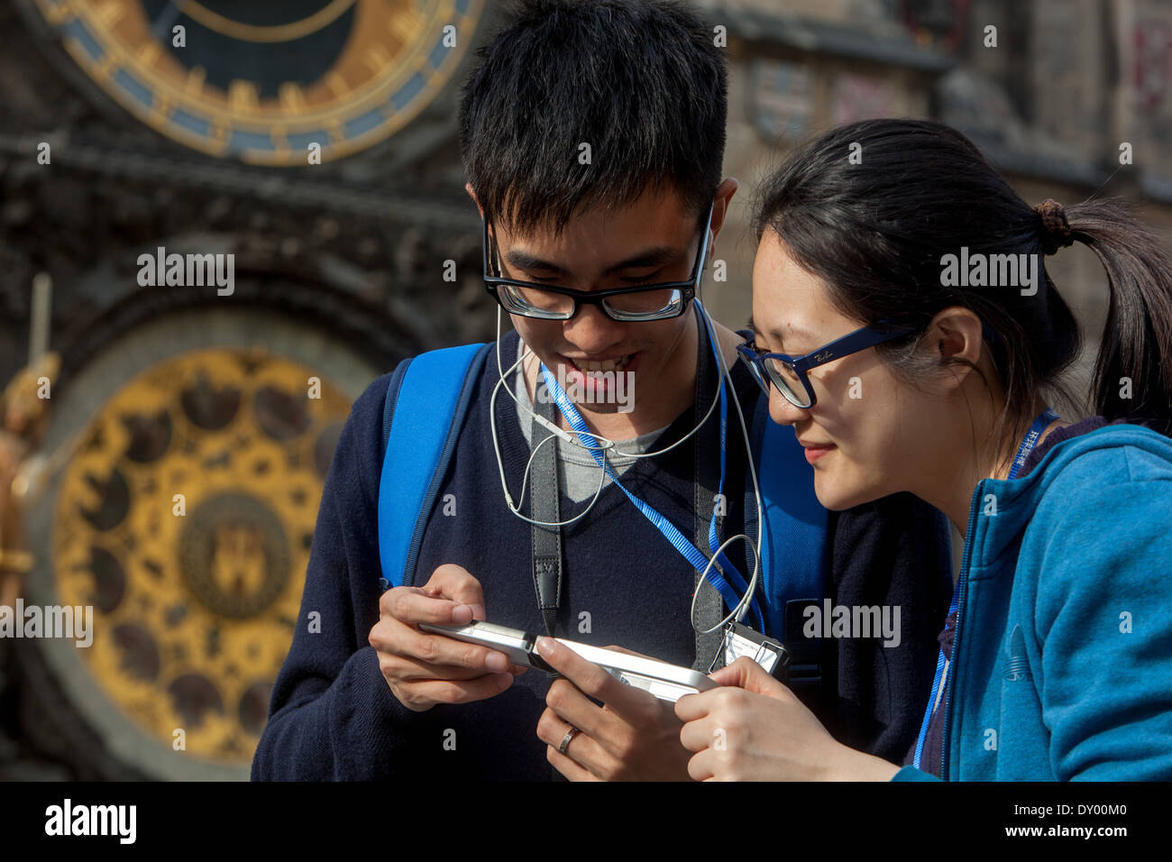 Young Asian tourists couple sightseeing at the Prague Astronomical Clock Stock Photo