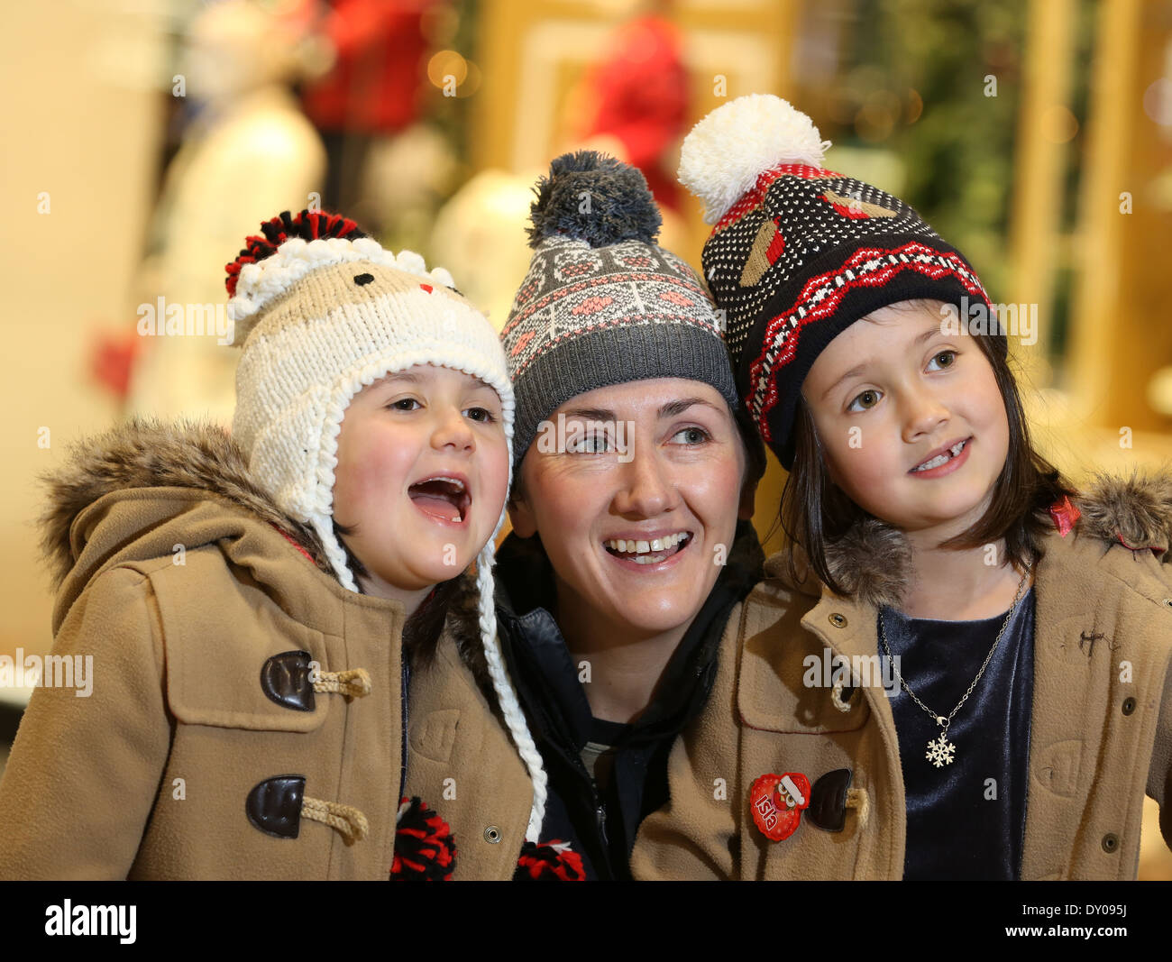 A mum and her two daughters having fun in wooly bobble hats Stock Photo