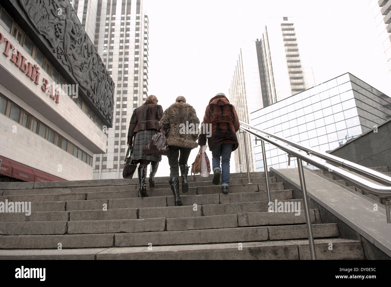 Three women climb steps in the Izmailovo Gamma Delta Hotel complex. Stock Photo