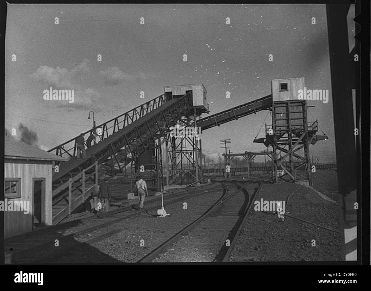 This 1952 photograph shows a conveyor belt coal loader in Newcastle, Australia. The image captures the industrial process of coal loading, a vital part of the region’s mining industry at the time. The photo is a nitrate negative preserved by the State Library of New South Wales. Stock Photo