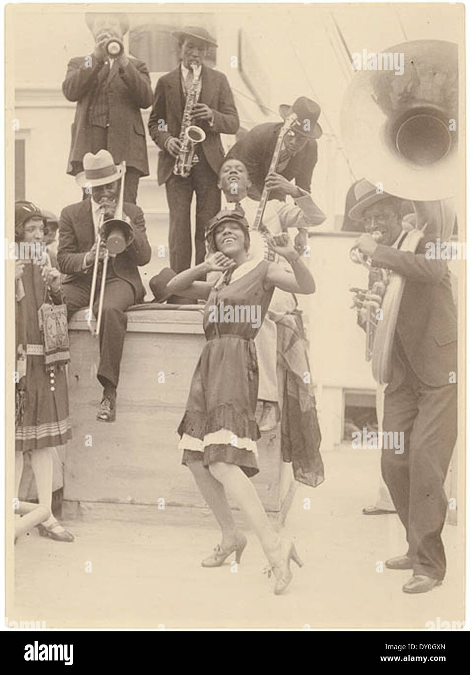 This 1928 photograph by Sam Hood shows the Colored Idea Band of Sonny Clay arriving in Sydney, Australia. The band, known for their jazz music and unique style, was part of the cultural exchange between the U.S. and Australia during the Jazz Age. Stock Photo