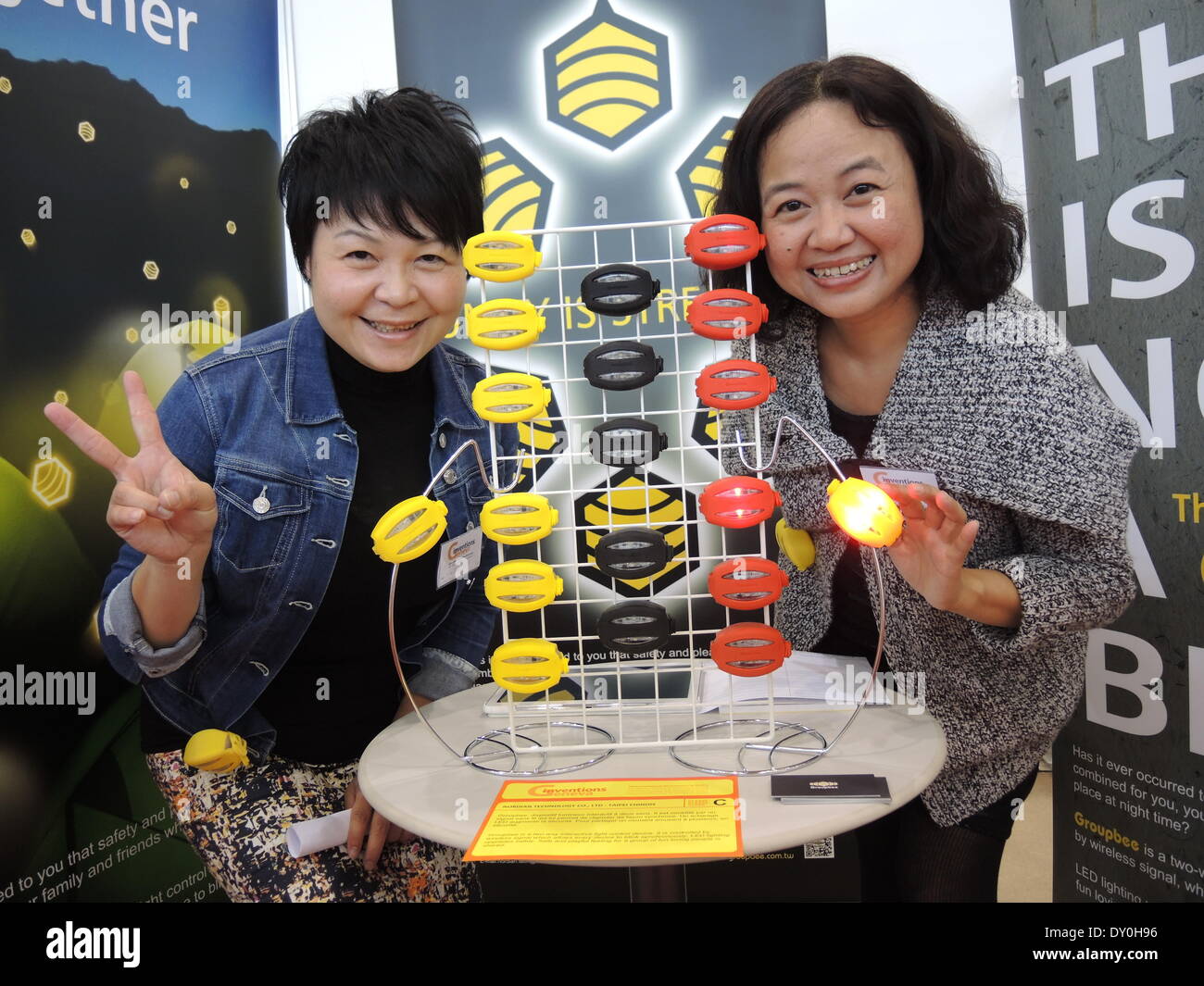 Geneva, Switzerland. 02nd Apr, 2014. The Taiwan-Chinese woman Vicki Chiu (R) and an assistant offer LED lights which are programmed in order to flash synchronic if selected partners meet with each other at the fair of inventors in Geneva, Switzerland, 02 April 2014. Photo: Thomas Burmeister/dpa/Alamy Live News Stock Photo