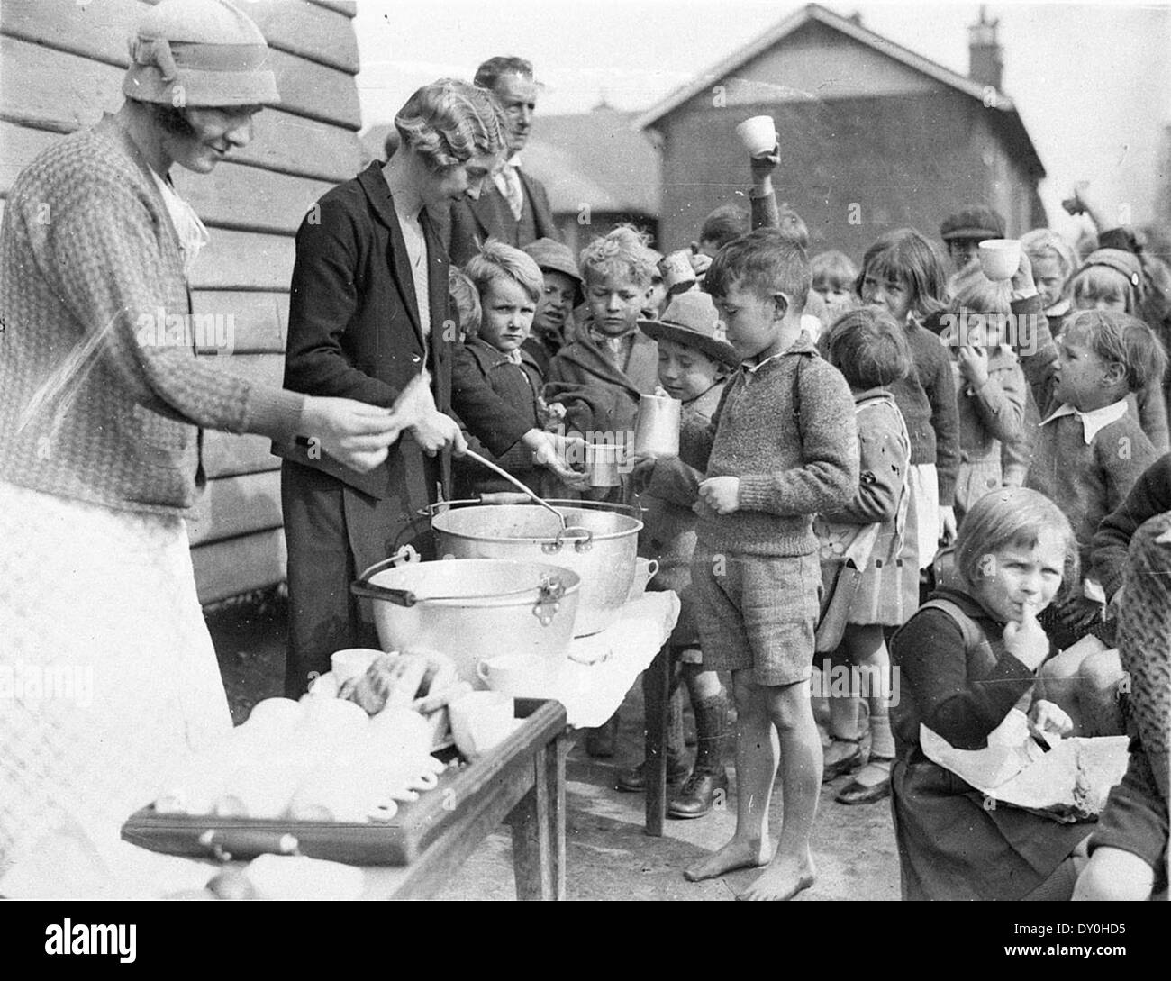 Schoolchildren line up for free issue of soup and a slice of bread in the Depression, Belmore North Public School, Sydney, 2 August 1934 / Sam Hood Stock Photo