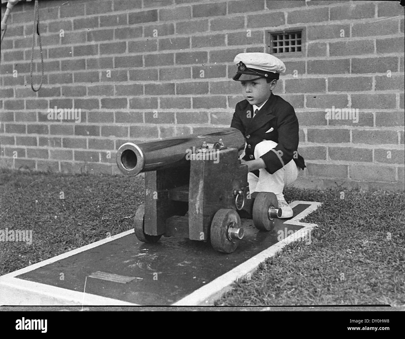 Boris Neville plays with the cannon in front of the new clubhouse at the Royal Motor Yacht Club of NSW, Rose Bay, Sydney, at the start of the motor boat season, 19 September 1936 / Sam Hood Stock Photo