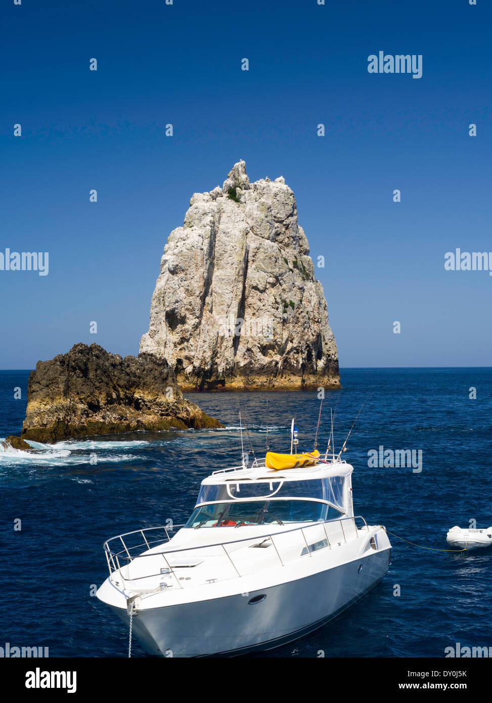 High Peak Rocks with a boat in the foreground. View of Poor Knights Islands, summer, Northland, New Zealand Stock Photo