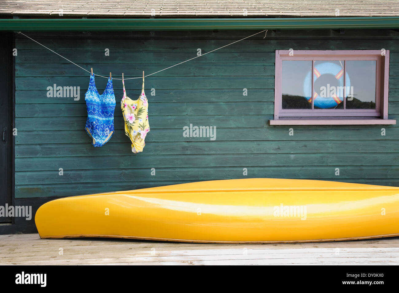 Bathing Suits On Clothes Line With Yellow Canoe Against Cottage