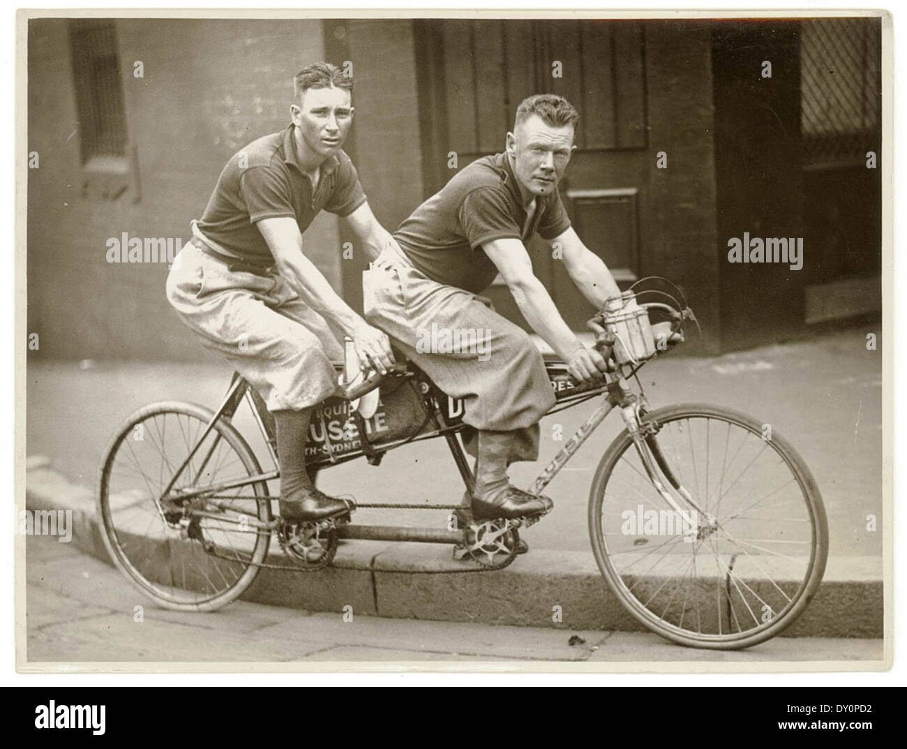 Two men in plus-fours on a tandem, by Sam Hood Stock Photo