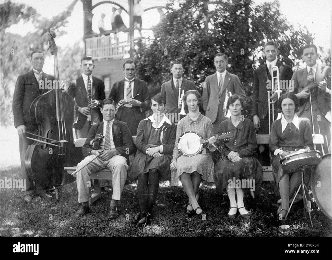 This photograph from c. 1930 shows the Deniliquin Musical Society and Orchestra in Deniliquin, New South Wales. It features musicians playing various instruments in an outdoor setting, capturing a historical moment in the town’s cultural history. Stock Photo