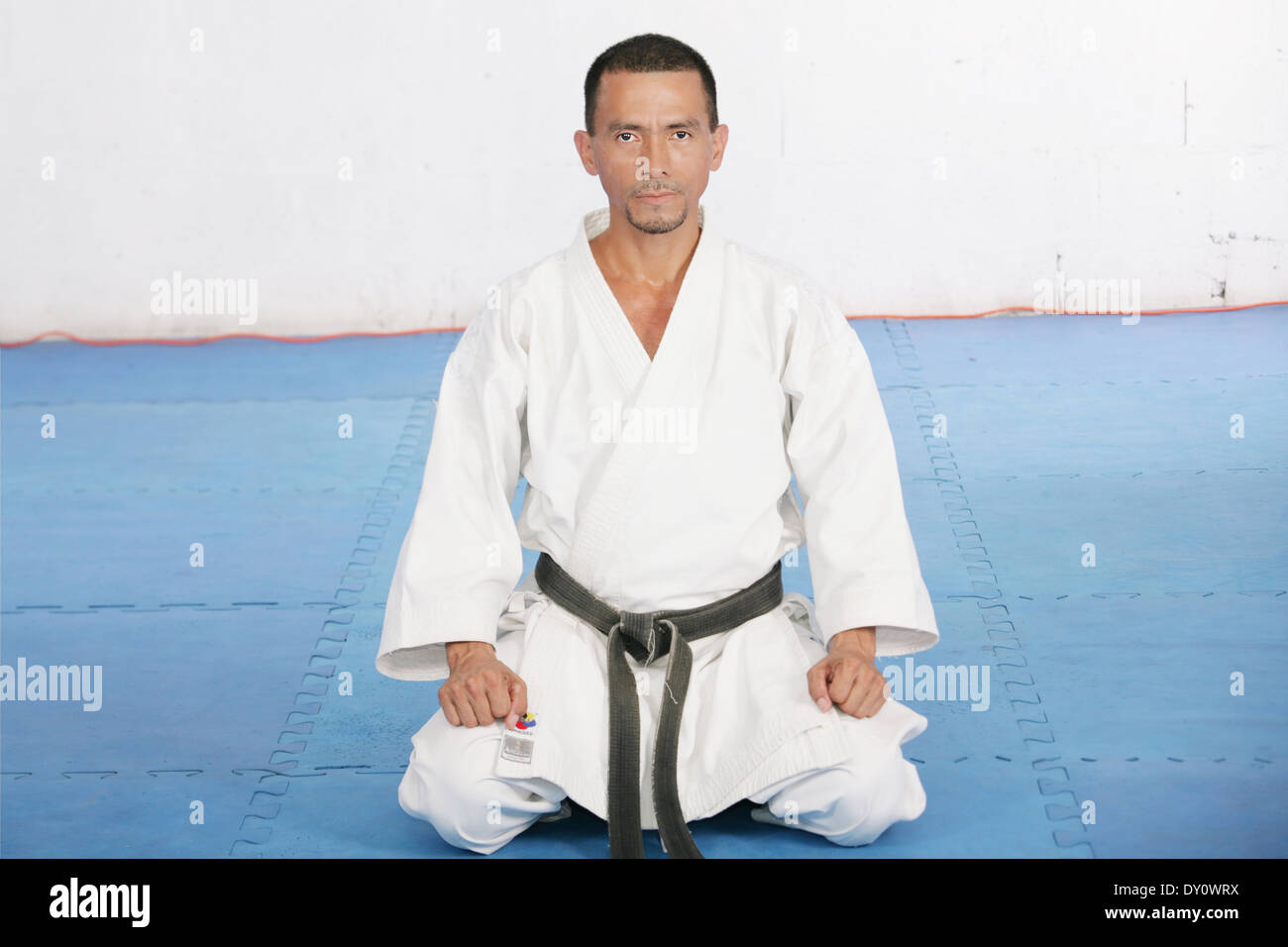 Black Belt karate man sit on a position to start or finish practicing Stock Photo