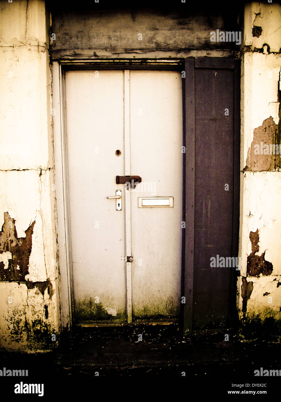 Padlocked door in worn facade Stock Photo