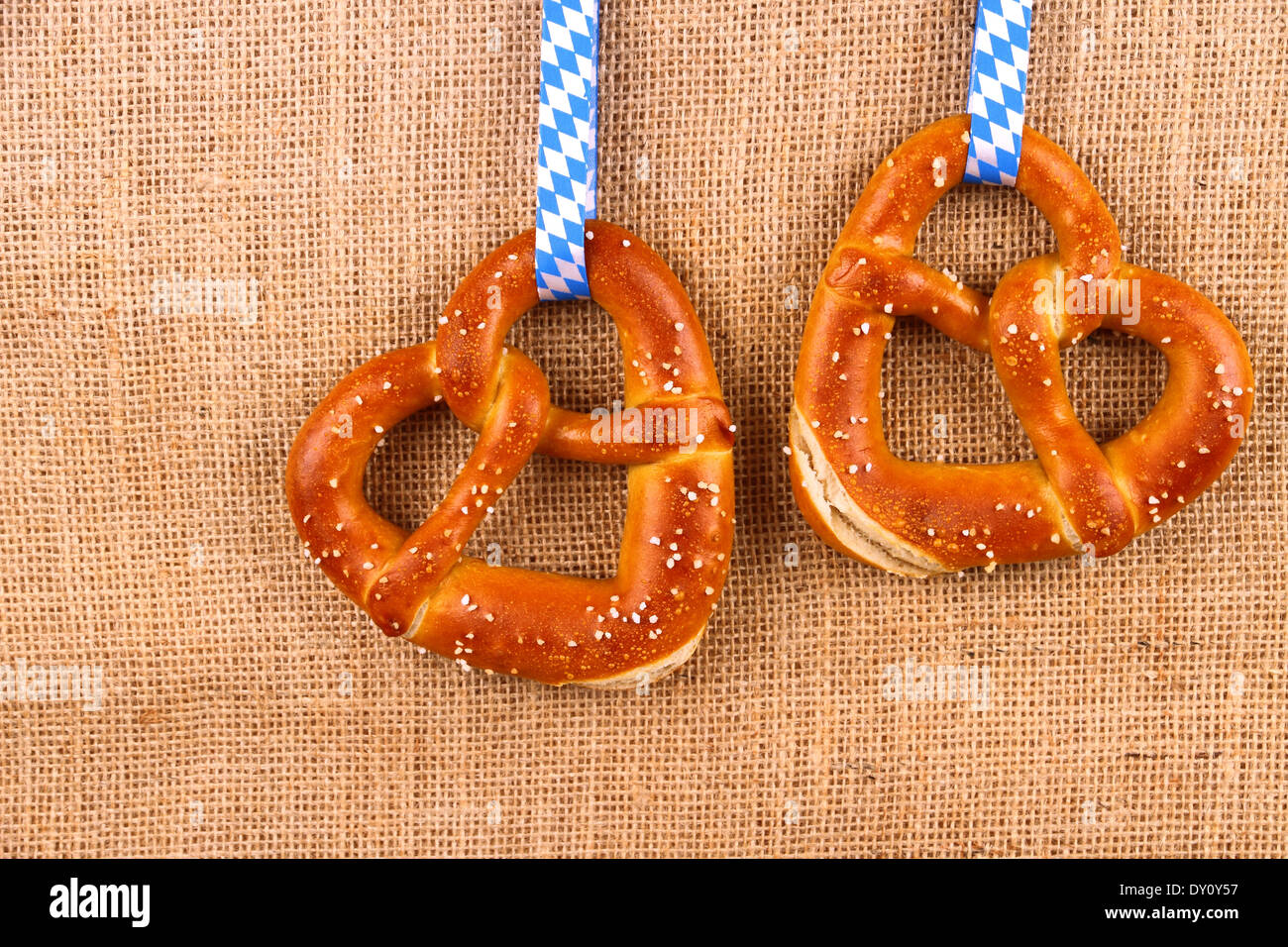 Two pretzel in heart shape on jute background, top view Stock Photo