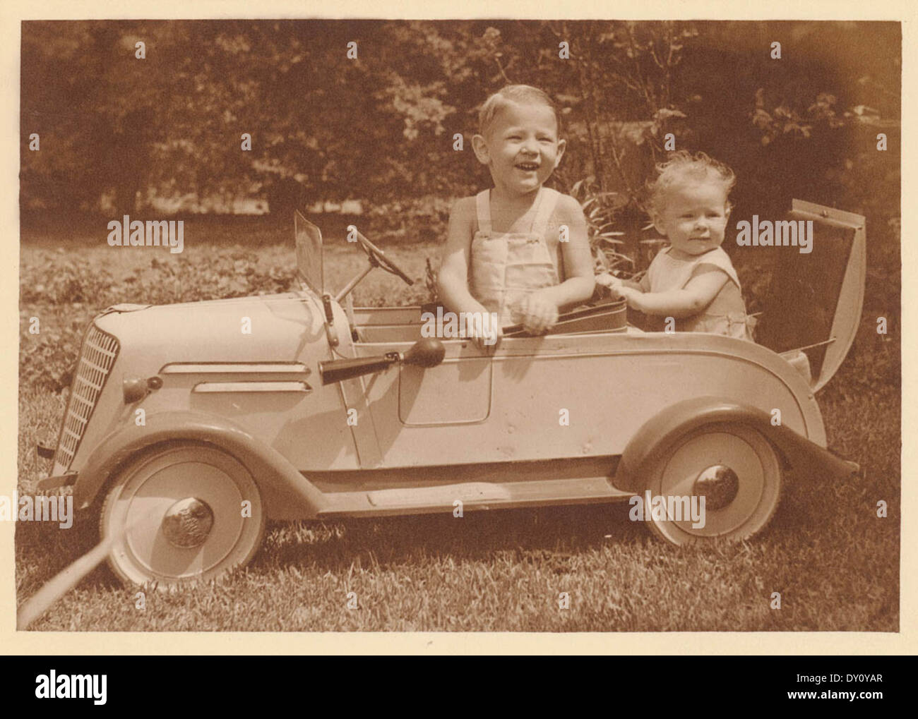 Boy in pedal car with baby in 'rumble seat', Sydney, ca. 1935