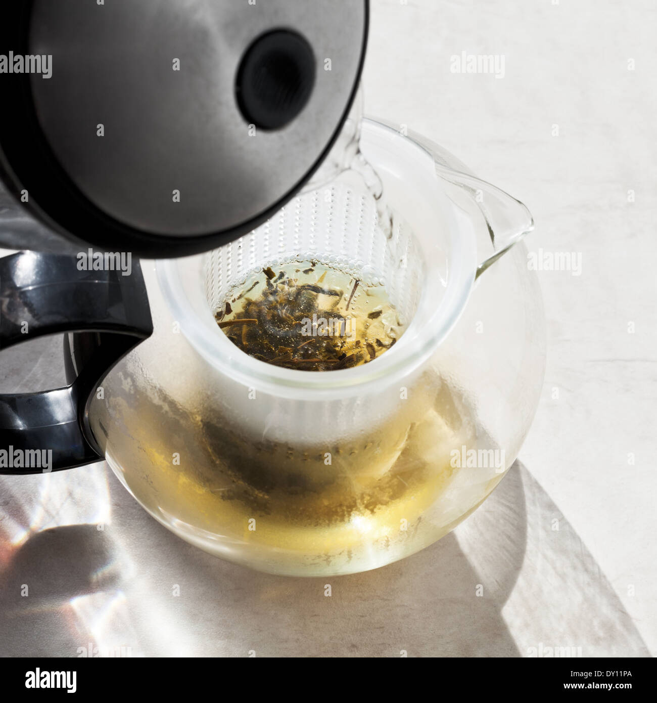 making green tee in teapot with boiling water Stock Photo