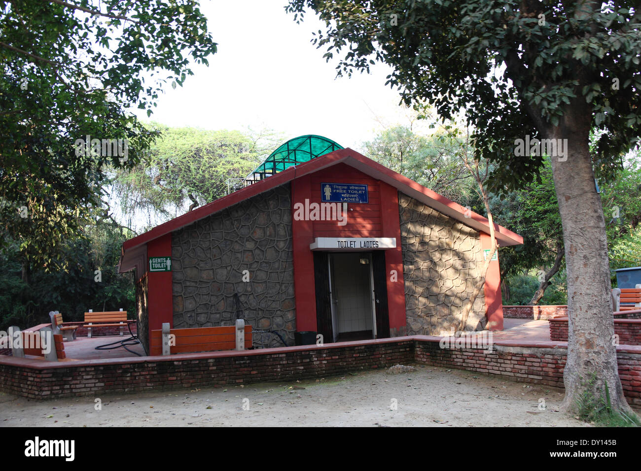Public convenience (Ladies toilet) inside the Delhi zoo, as a separate building with stone tiles and with tree in front Stock Photo