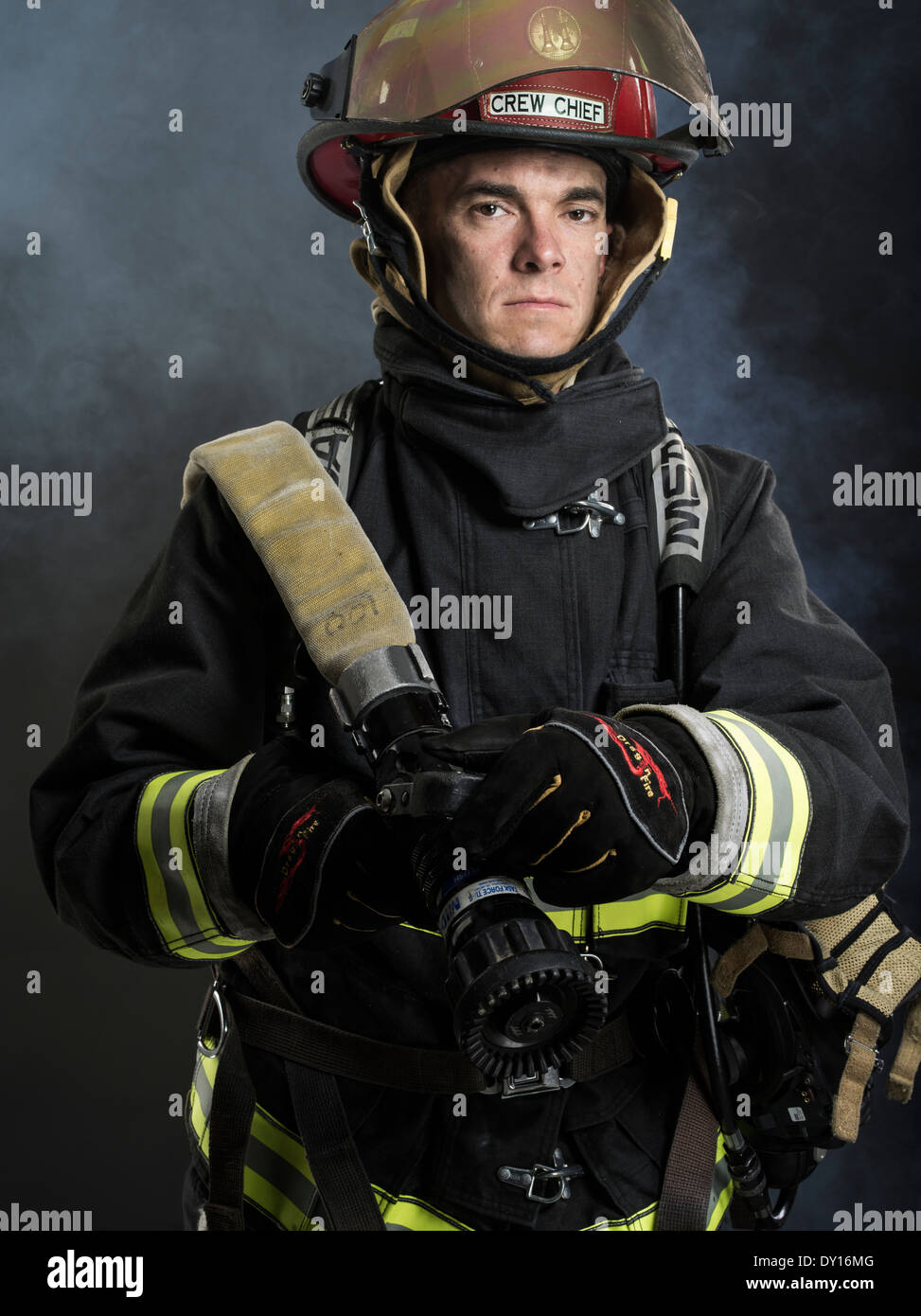 Male firefighter in structural firefighting uniform with breathing apparatus and axe Stock Photo