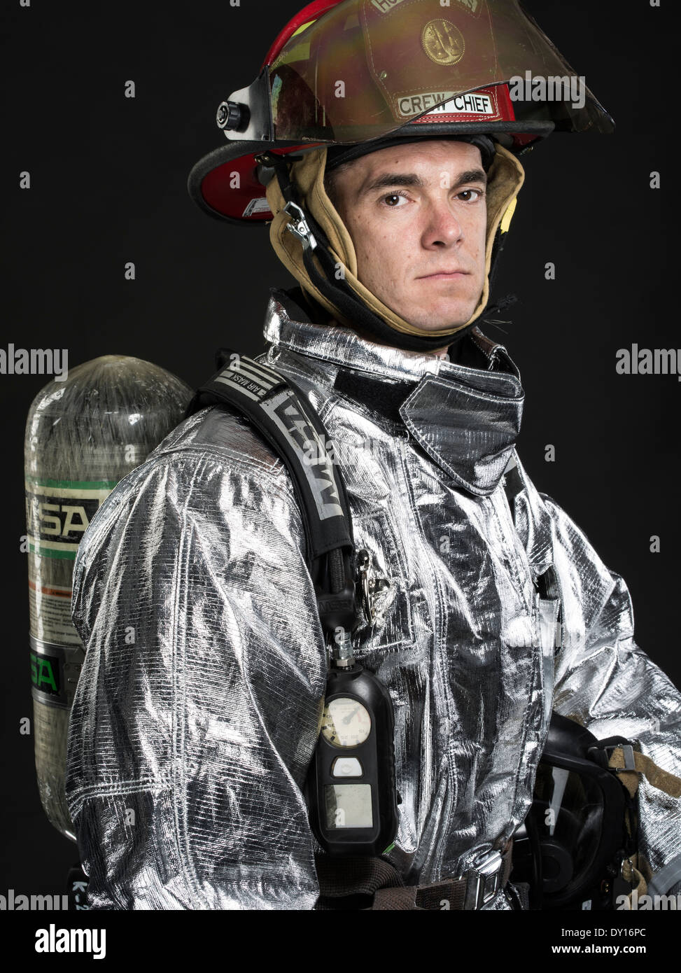 Male firefighter in high temperature aviation fuel   firefighting uniform with breathing apparatus and axe Stock Photo