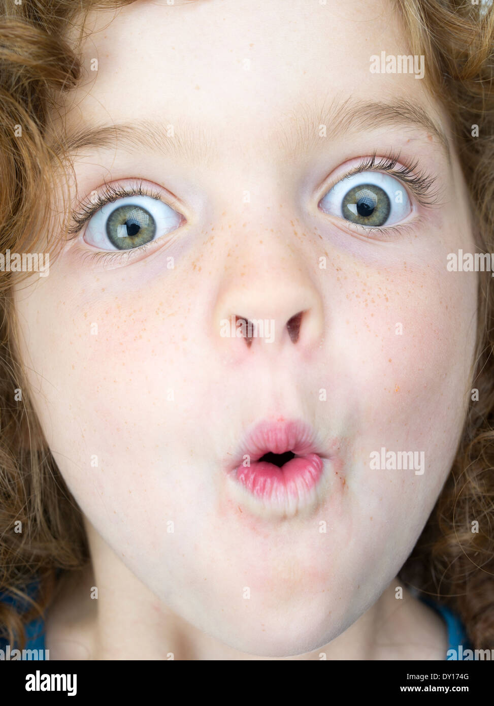 Young girl with red hair and big eyes with surprised expression Stock Photo