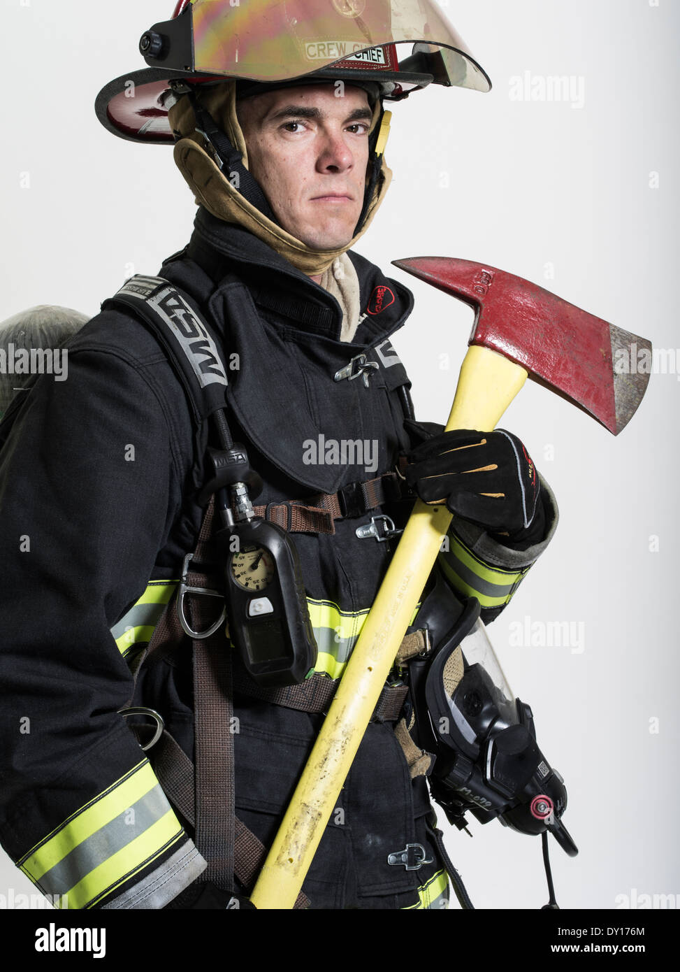 Male firefighter in structural firefighting uniform with breathing apparatus and axe Stock Photo