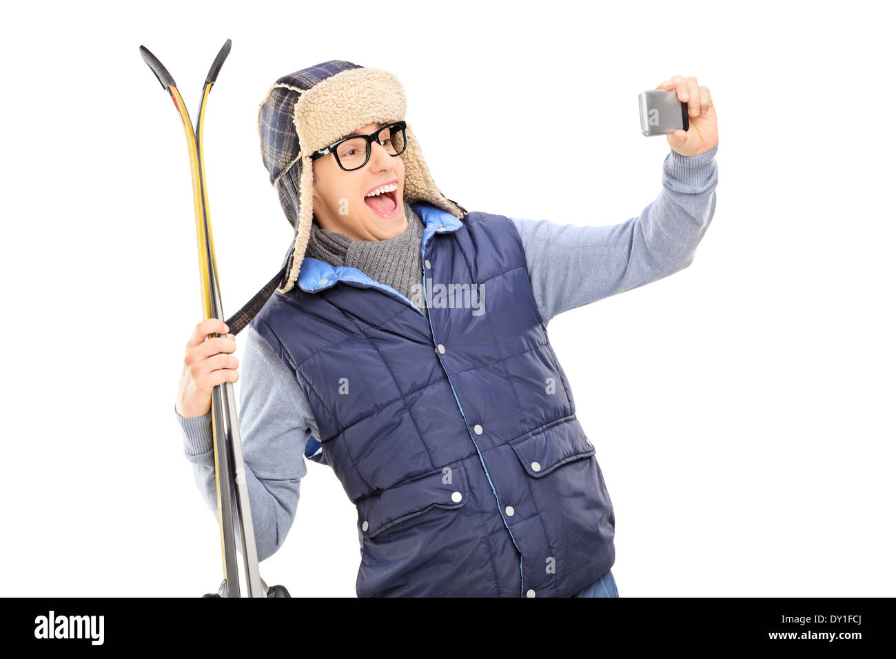 Man in winter clothes taking a selfie with skis Stock Photo