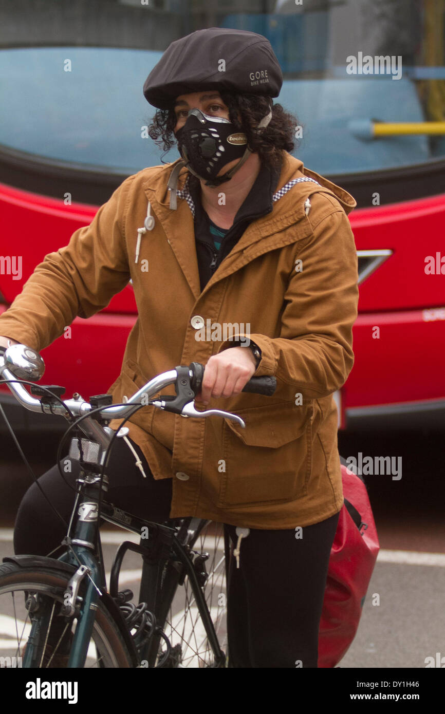 London, UK. 3rd April 2014. A cyclist with a mask to protect from the Sahara smog and pollutants  as (DEFRA) Department for Environment Food and Rural Affairs warned of a high risk of air pollution in England caused by a mix of  European emissions and dust from the Sahara. Credit:  amer ghazzal/Alamy Live News Stock Photo