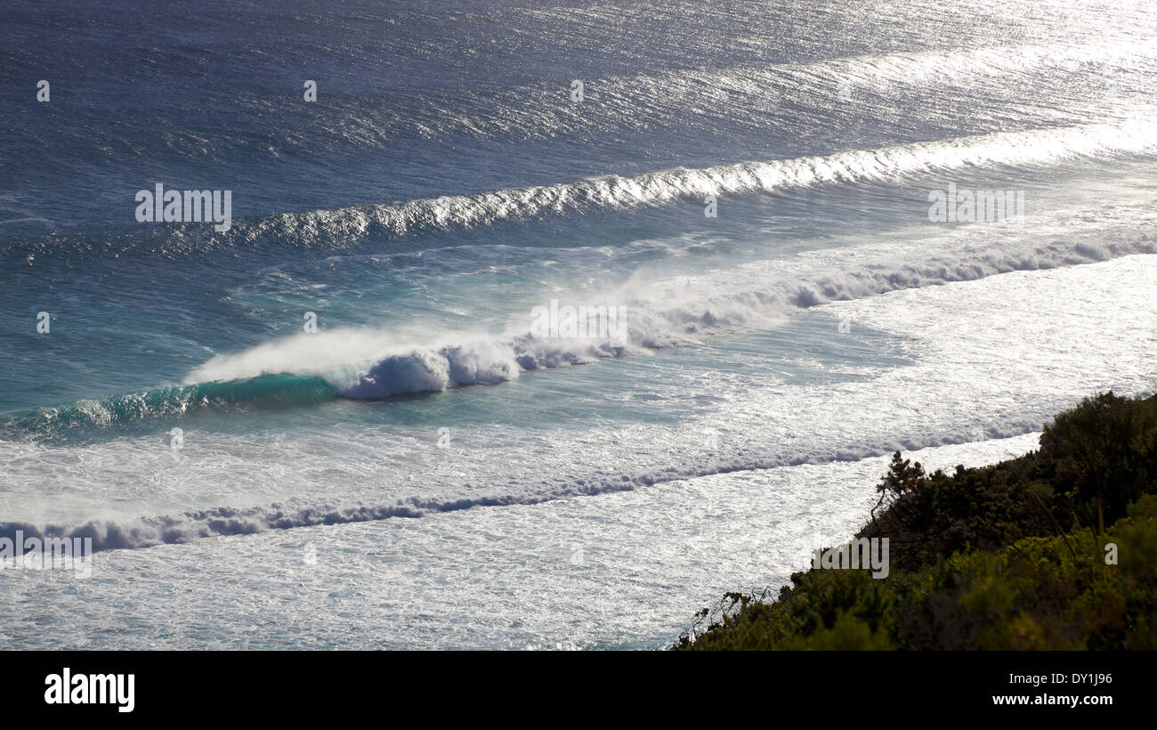 Backlit waves breaking below the Albany Wind Farm, near the town of Albany in Western Australia. Stock Photo