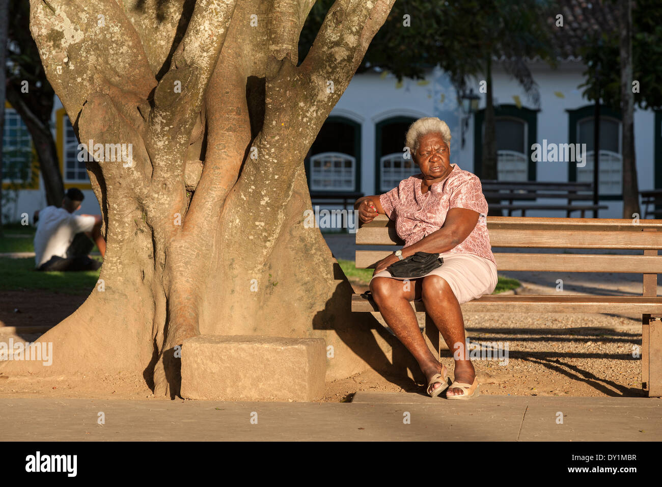 Paraty, colonial town, typical colonial houses, big tree, woman on the bench, Rio de Janeiro, Costa Verde, Brazil Stock Photo