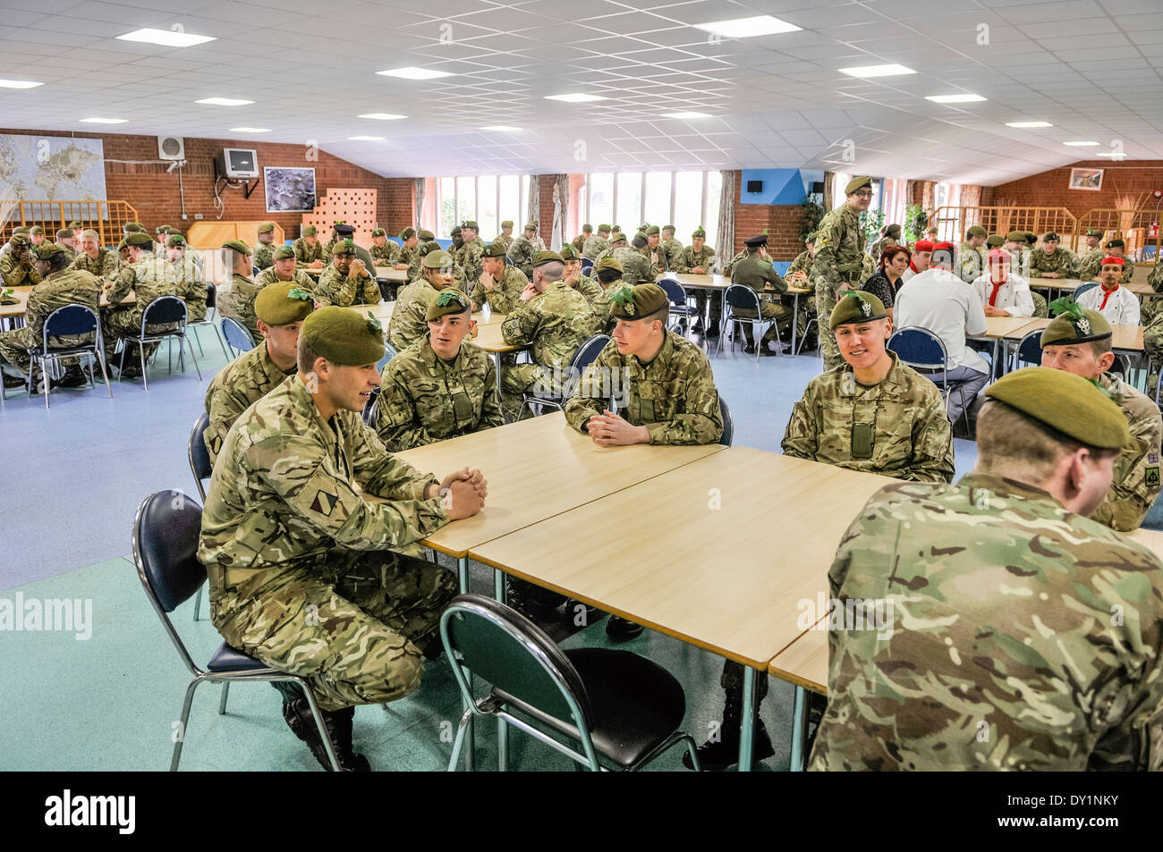 Soldiers sit around tables in a barracks mess. Stock Photo