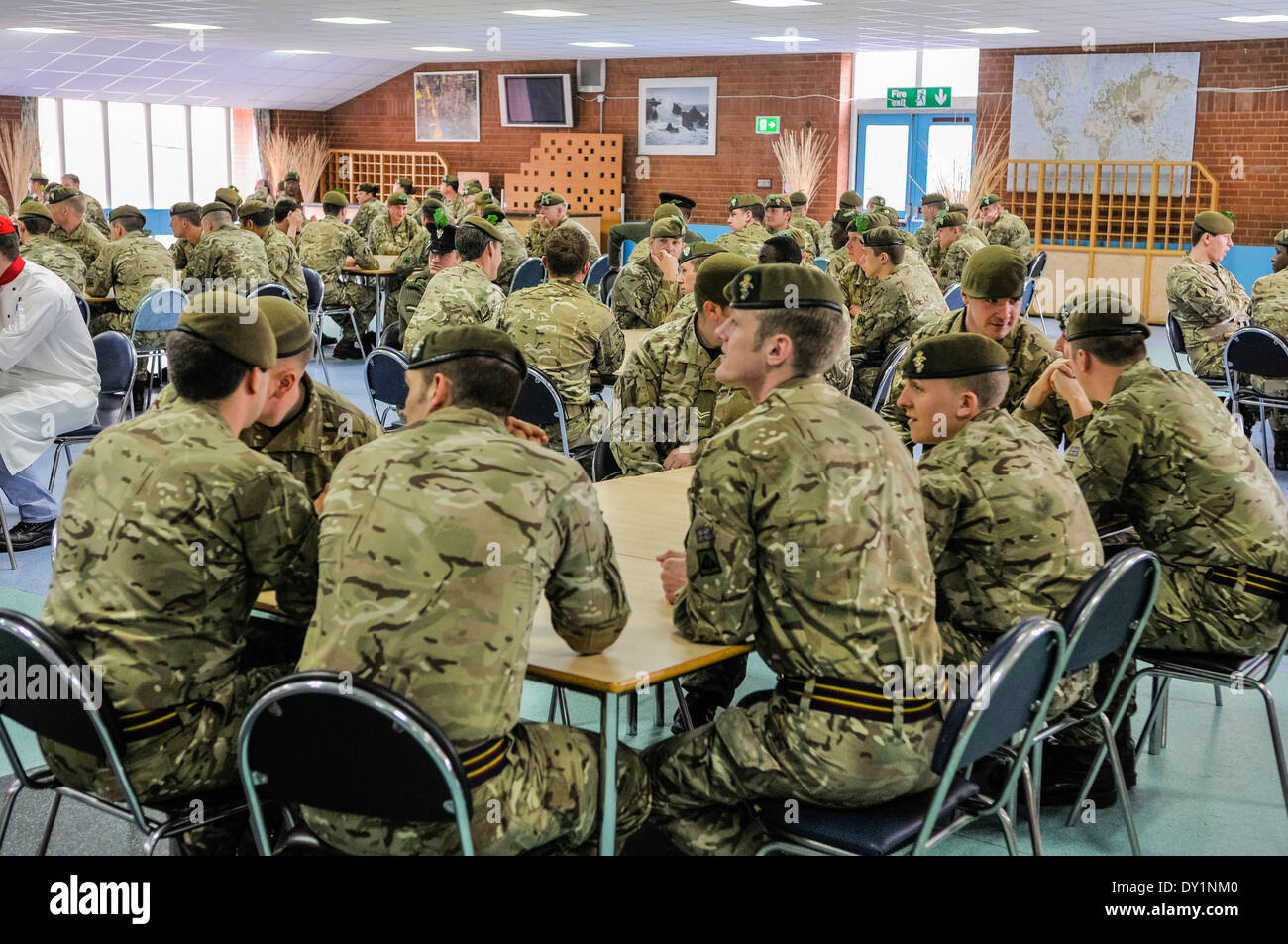 Soldiers sit around tables in a barracks mess. Stock Photo