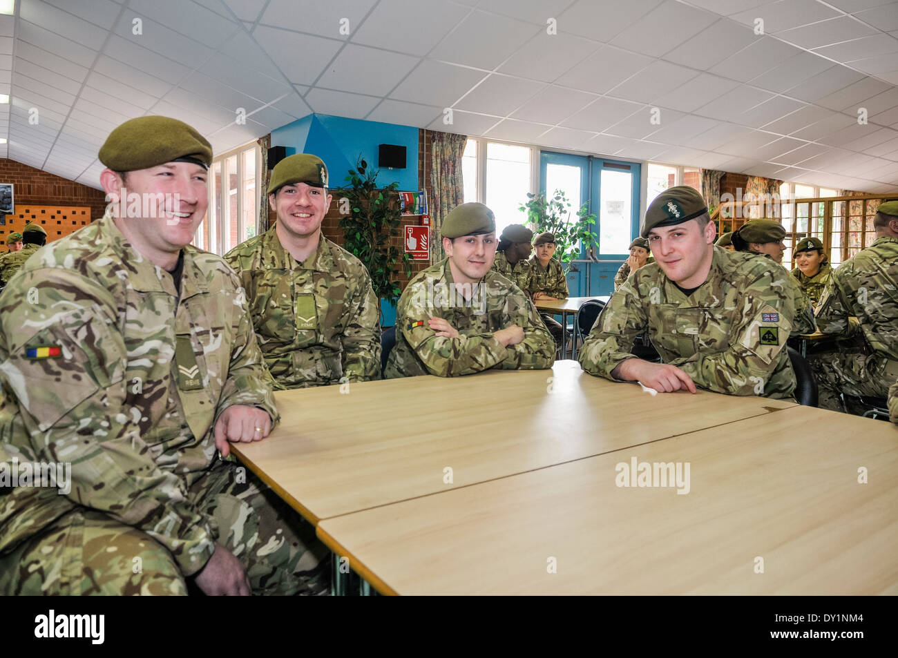 Soldiers sit around tables in a barracks mess. Stock Photo