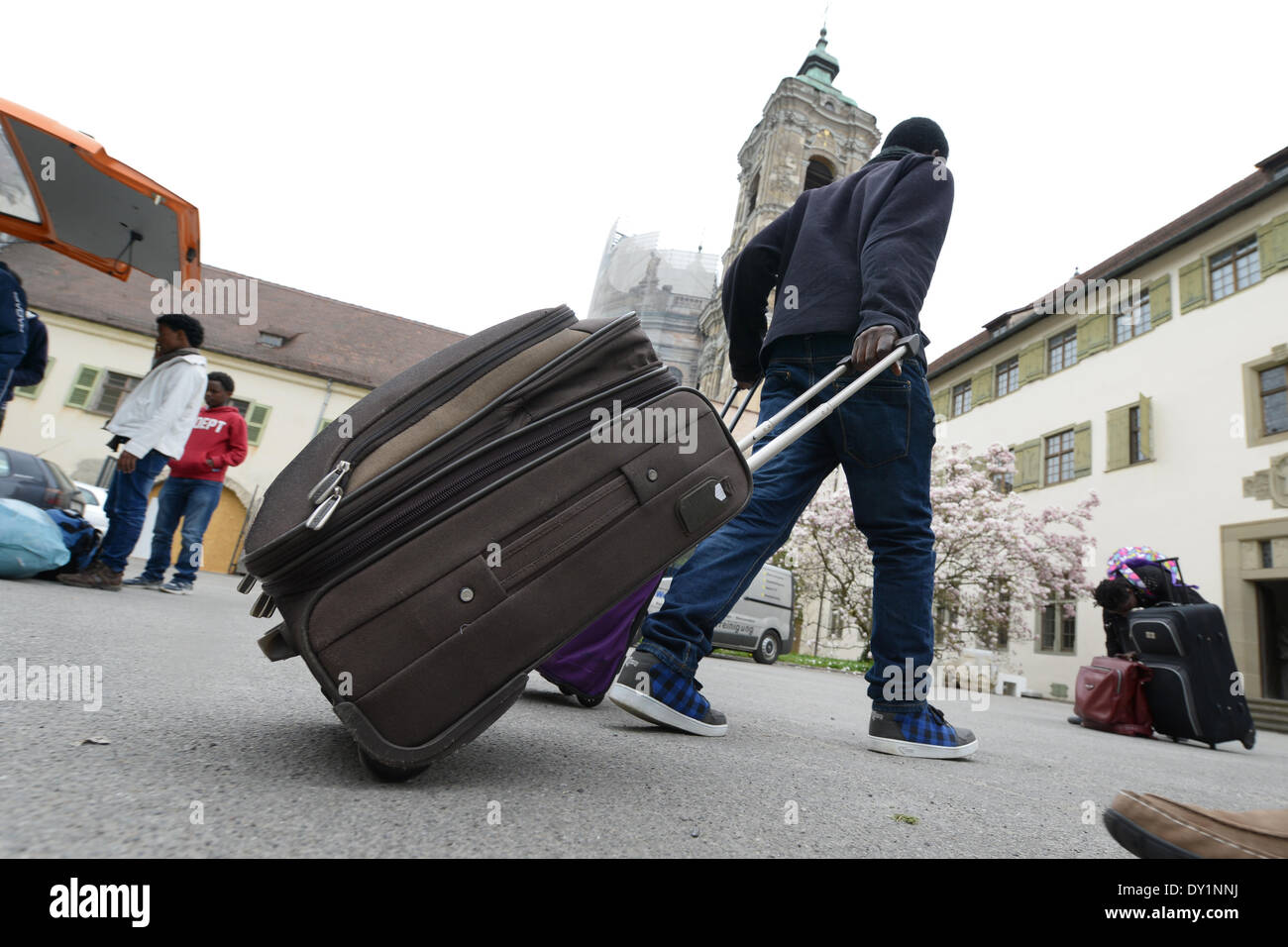 African refugees carry their luggage to the guesthouse of the Abbey in