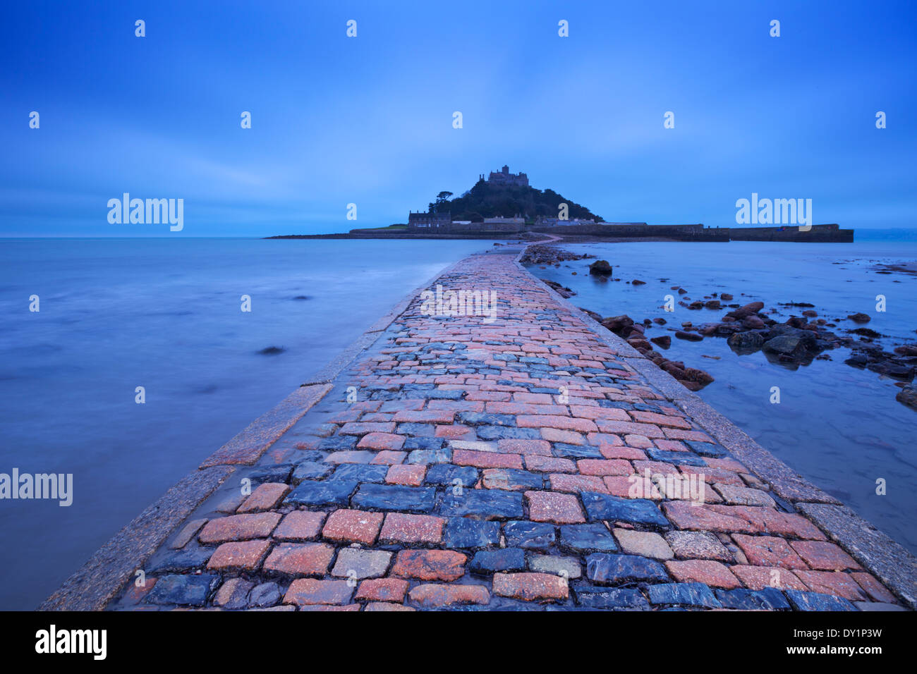 The causeway leading to Saint Michaels Mount in Cornwall, England at low tide, photographed in the blue hour at dawn Stock Photo