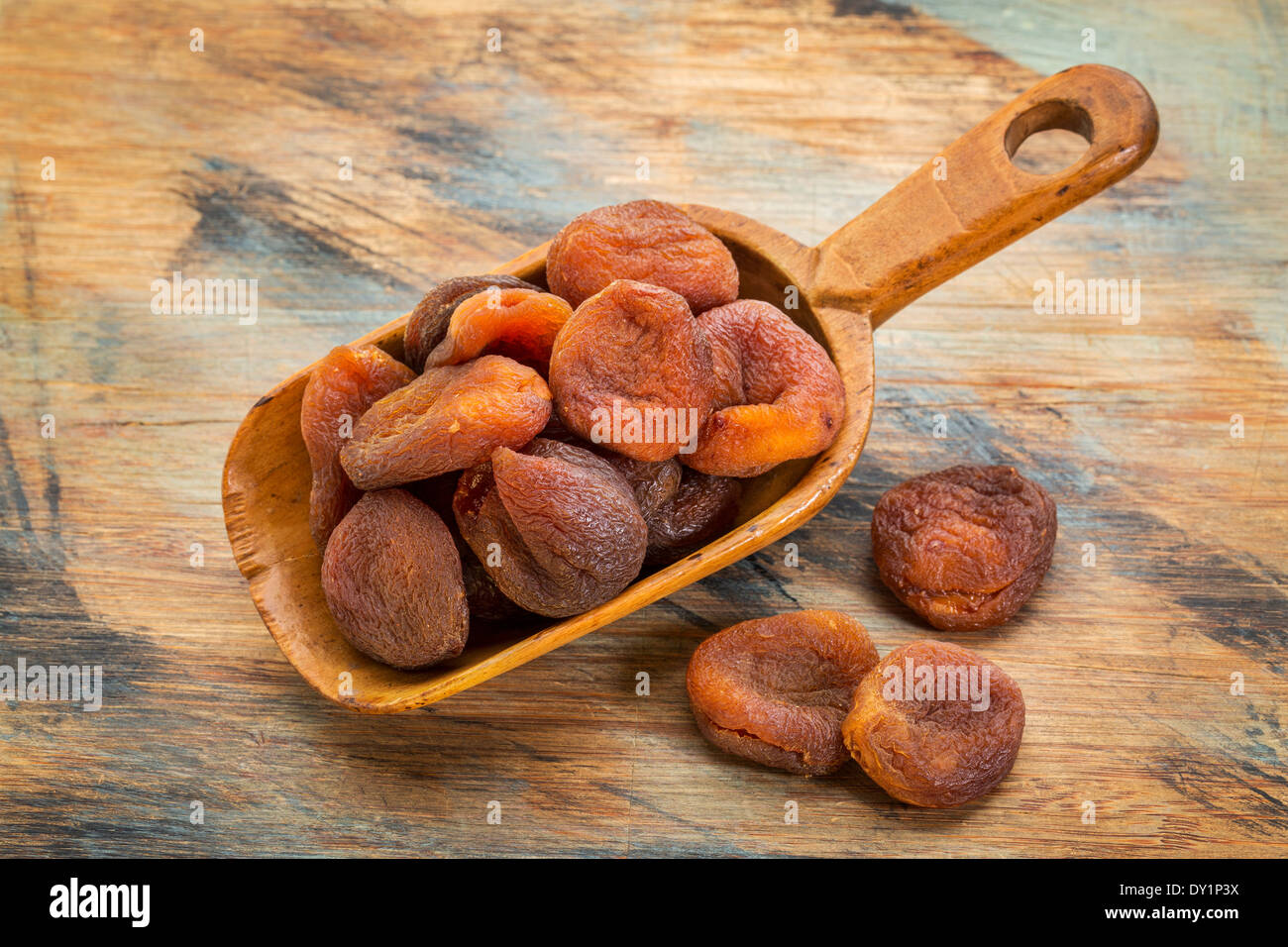 a pile of sun dried Turkish apricots on grunge painted wood surface Stock Photo