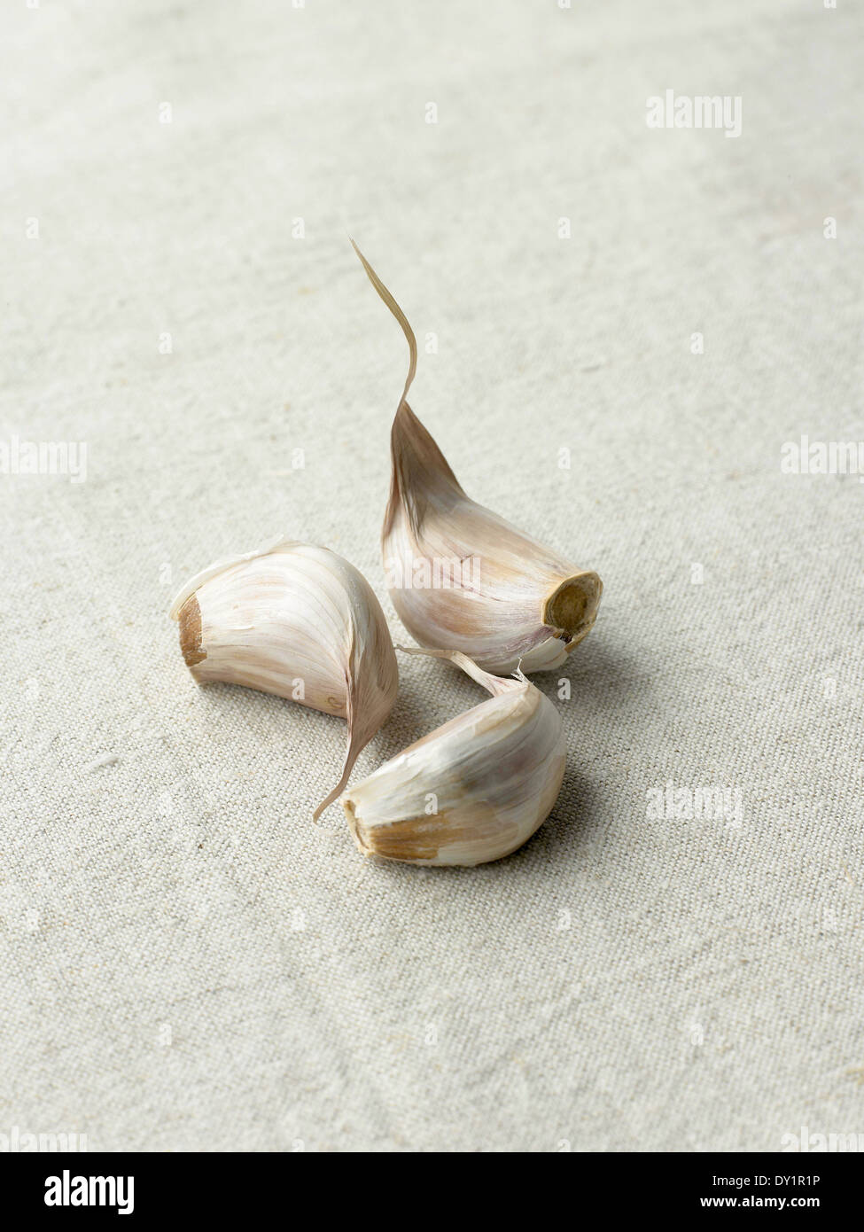 Three Garlic Cloves on Cloth Background Stock Photo - Alamy