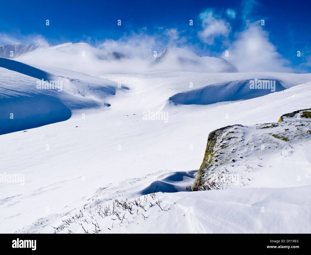 Rondane, Norway. Vast snow covered mountains with cloud clearing from the summits Stock Photo