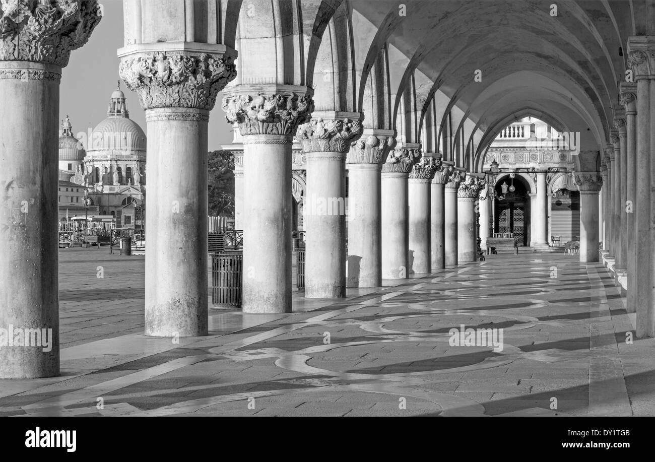 Venice - Exterior corridor of Doge palace and church Santa Maria della Salute in background. Stock Photo