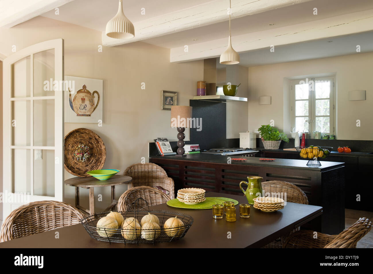 Cane chairs around a coated metal dining table in a kitchen with