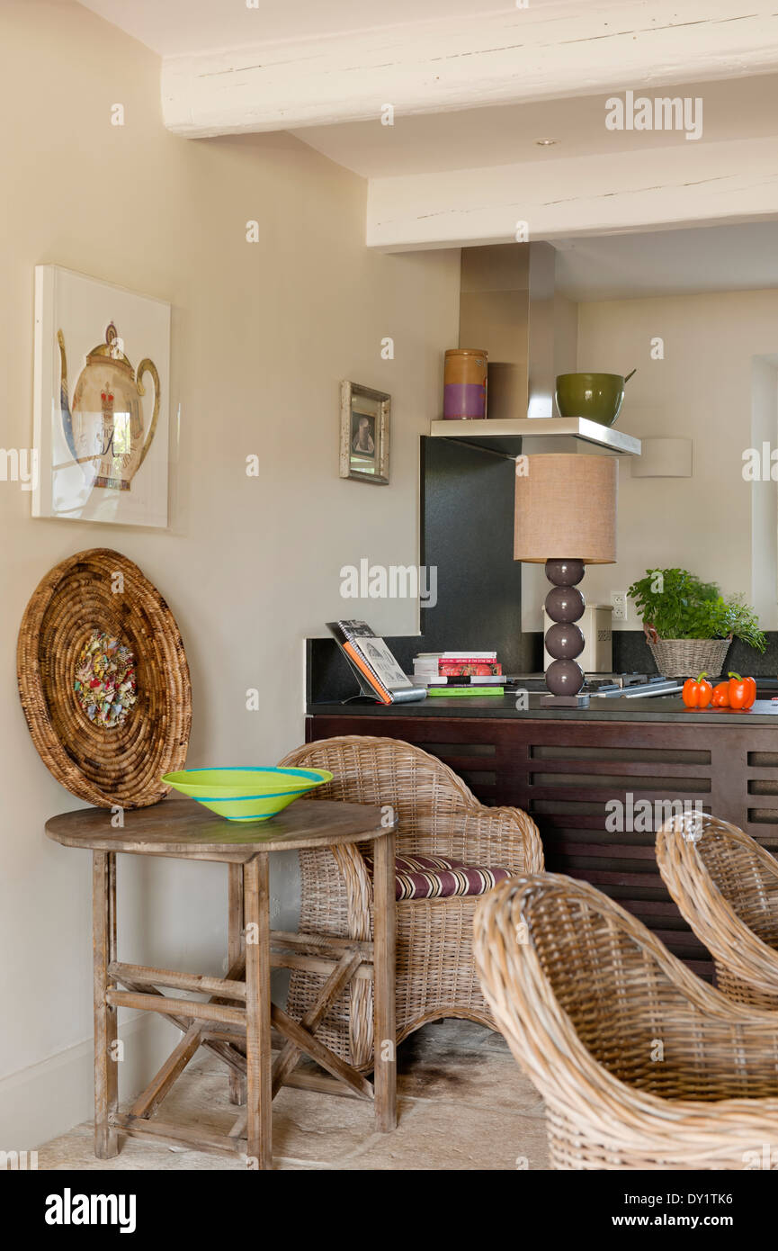 Provencal cane chairs in kitchen with traditional beamed ceiling and round wooden folding table