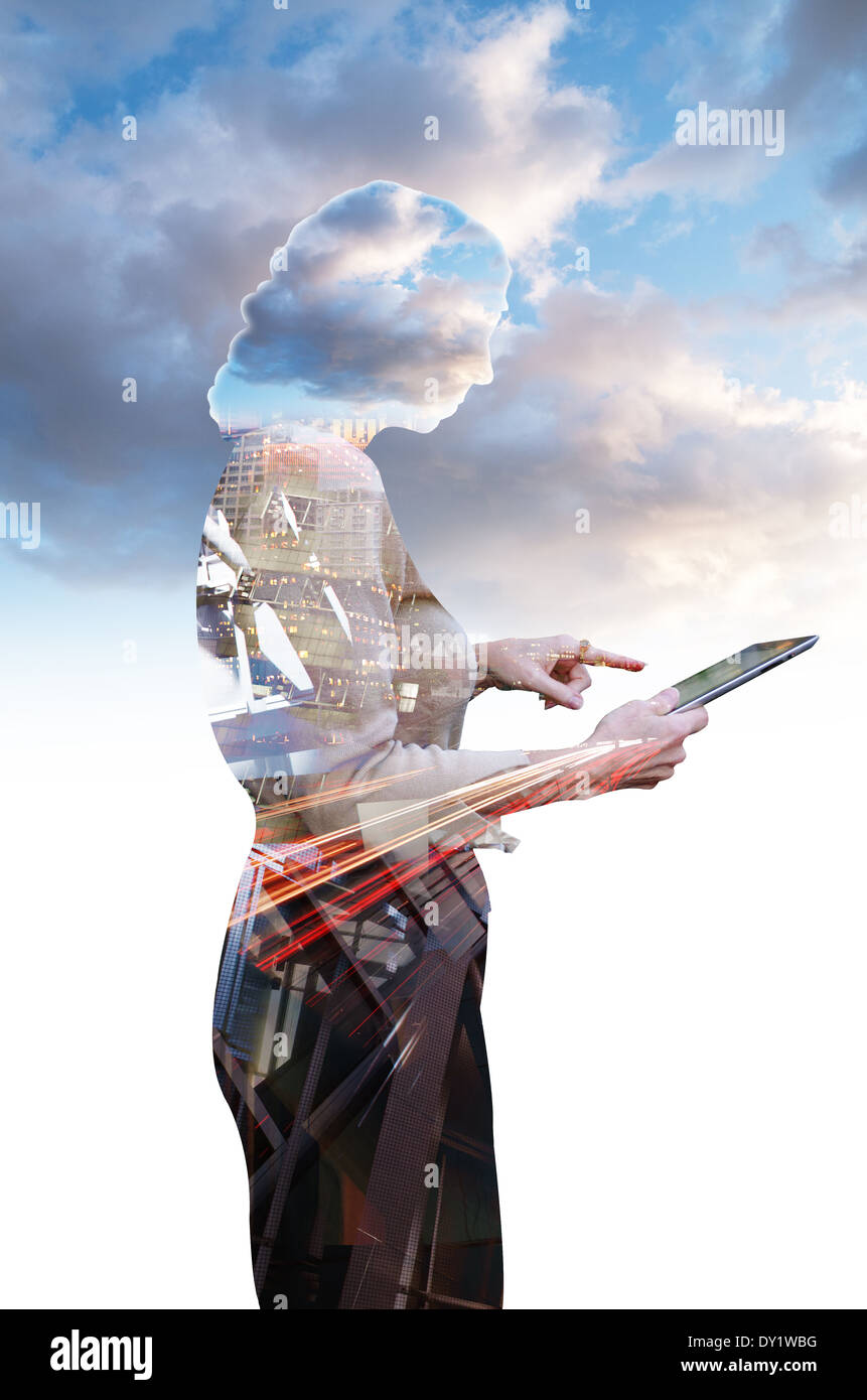 Businesswoman using a computer tablet composited with clouds Stock Photo