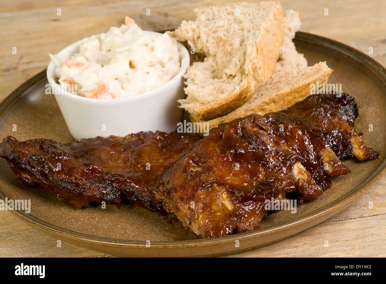 pork ribs in barbecue sauce with coleslaw and crusty bread Stock Photo
