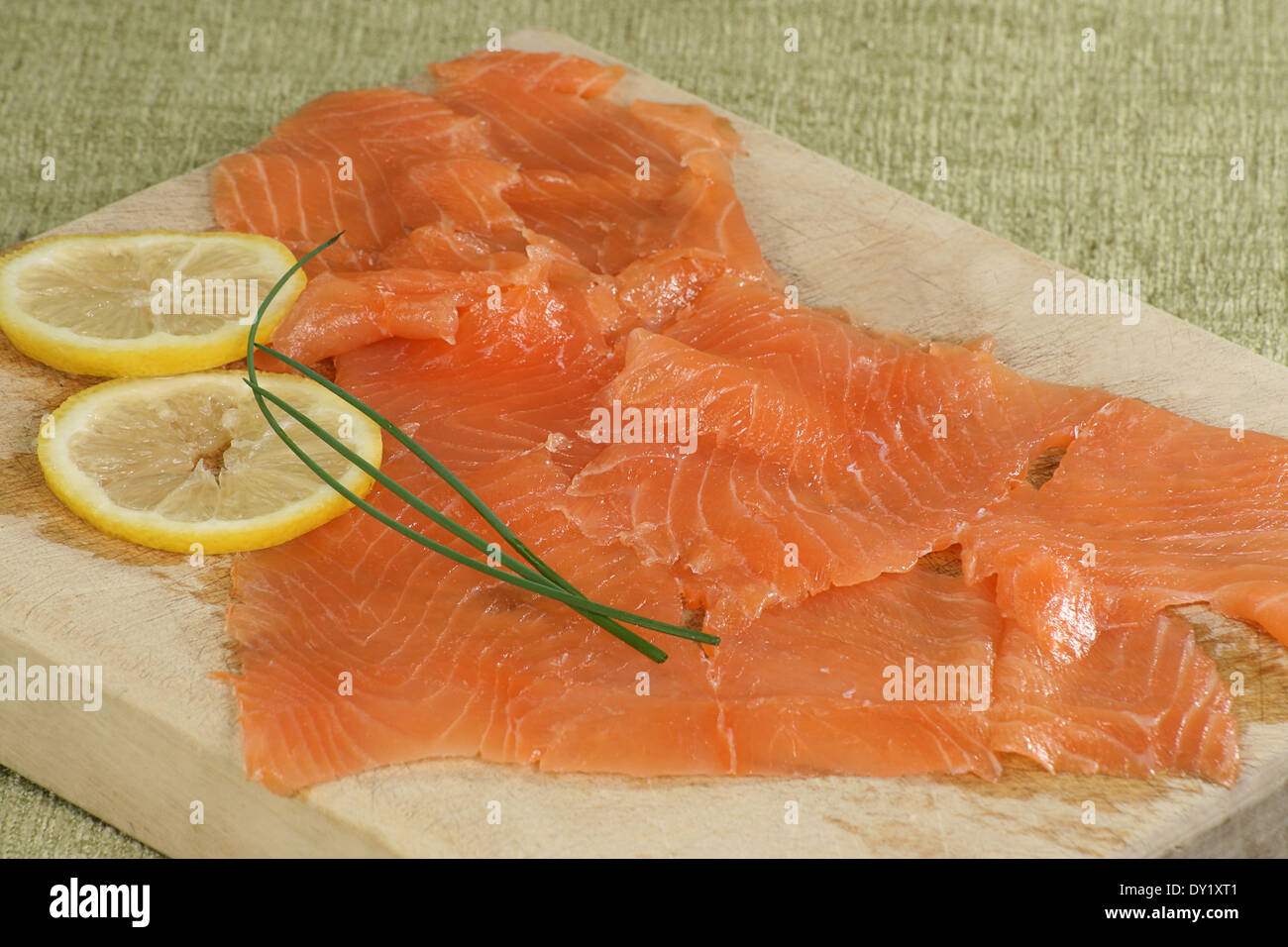 Thinly sliced smoked salmon with lemon on a wooden board Stock Photo