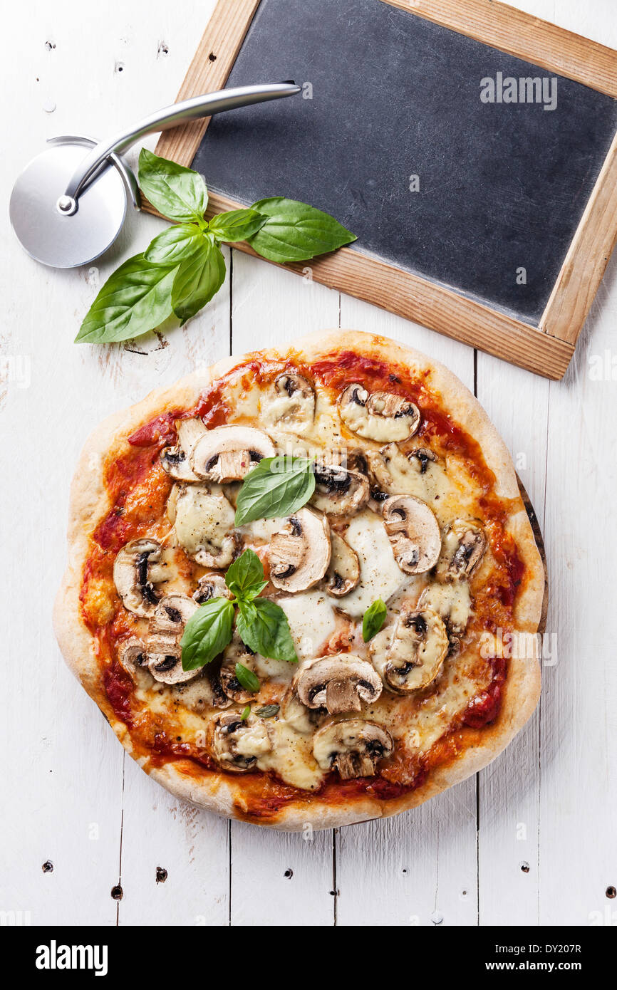 Pizza with mushrooms and basil on wooden table Stock Photo