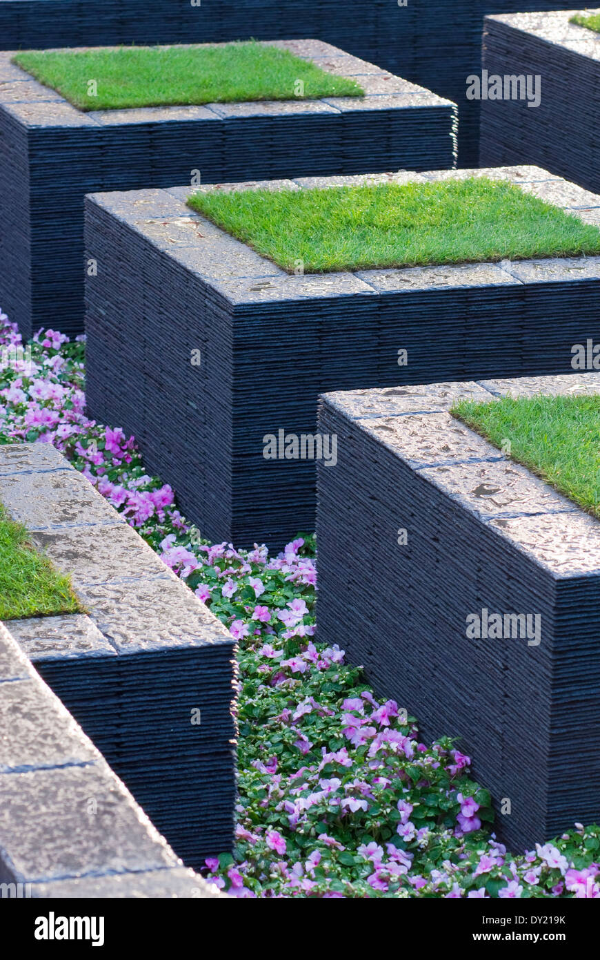 Slate stepping stones with turf and Impatiens 'Cupido Pink', Busy Lizzies planted between. Stock Photo